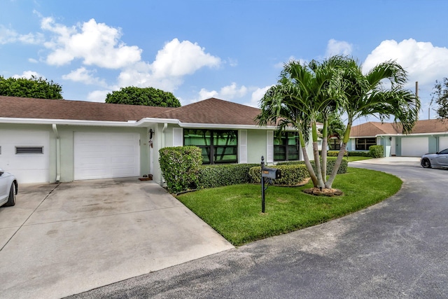 ranch-style house featuring stucco siding, a garage, roof with shingles, a front lawn, and concrete driveway