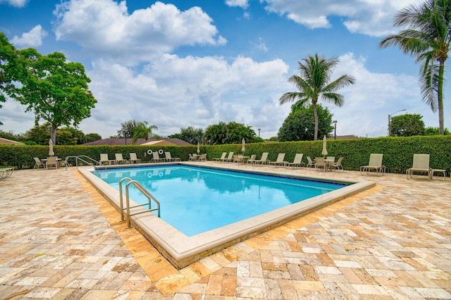 pool featuring fence and a patio area