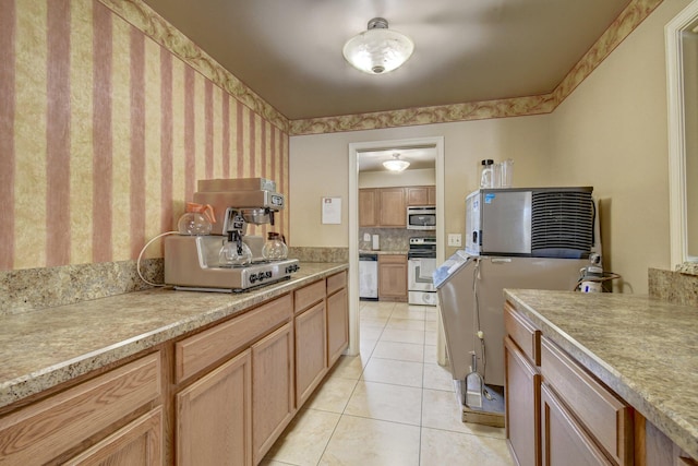 kitchen with stainless steel appliances, light tile patterned flooring, and light countertops