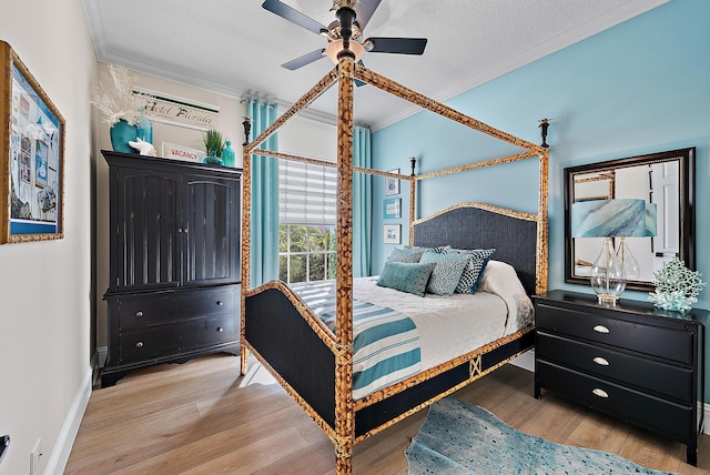 bedroom with ornamental molding, a ceiling fan, a textured ceiling, wood finished floors, and baseboards