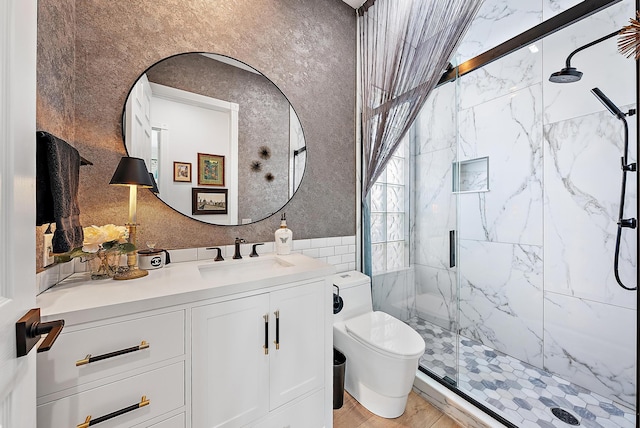 bathroom with a marble finish shower, toilet, vanity, and tile walls