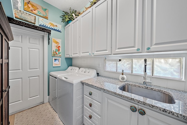 laundry room featuring cabinet space, washer and dryer, and a sink