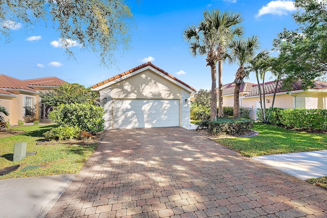 mediterranean / spanish house with stucco siding, a front lawn, a tile roof, decorative driveway, and a garage