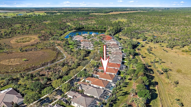 birds eye view of property featuring a forest view, a residential view, and a water view