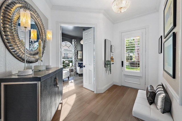 foyer entrance with crown molding, wood finished floors, and baseboards