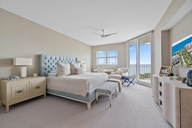 bedroom with light colored carpet, ceiling fan, access to outside, a textured ceiling, and floor to ceiling windows