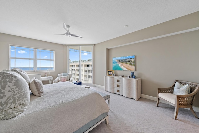 bedroom featuring light carpet, ceiling fan, a textured ceiling, and baseboards