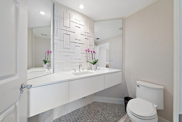 bathroom featuring recessed lighting, toilet, vanity, baseboards, and tile patterned floors