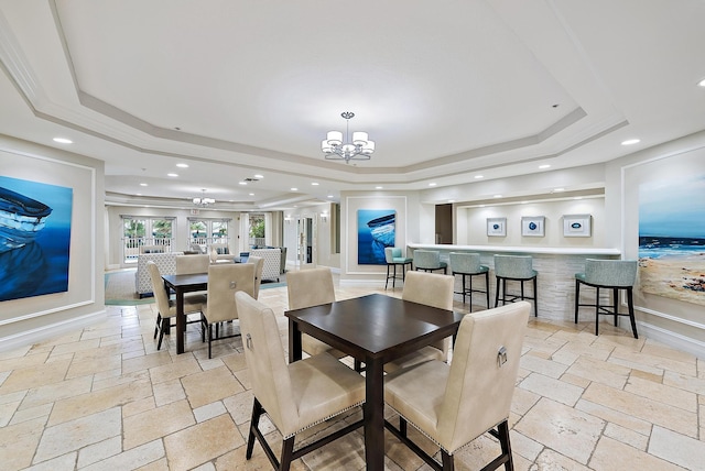 dining room featuring a chandelier, recessed lighting, a raised ceiling, and stone tile floors