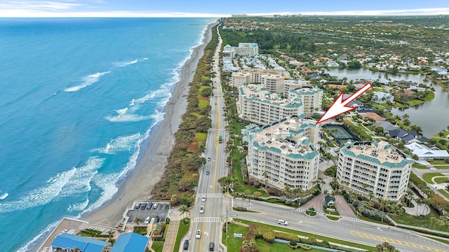 drone / aerial view featuring a beach view and a water view