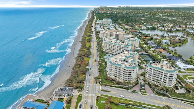 drone / aerial view featuring a view of city, a beach view, and a water view