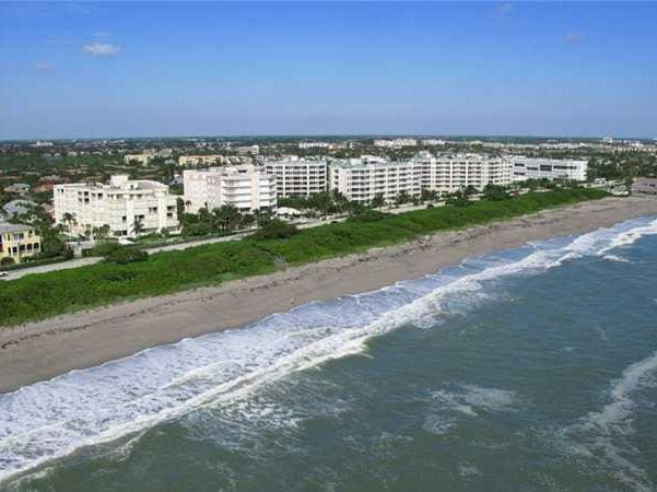 aerial view with a city view, a water view, and a beach view