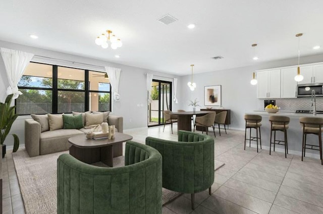 living area featuring baseboards, light tile patterned flooring, visible vents, and recessed lighting