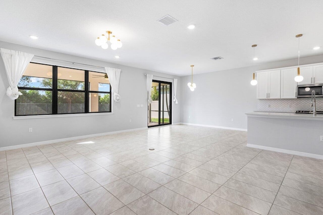 unfurnished living room with visible vents, baseboards, and light tile patterned flooring