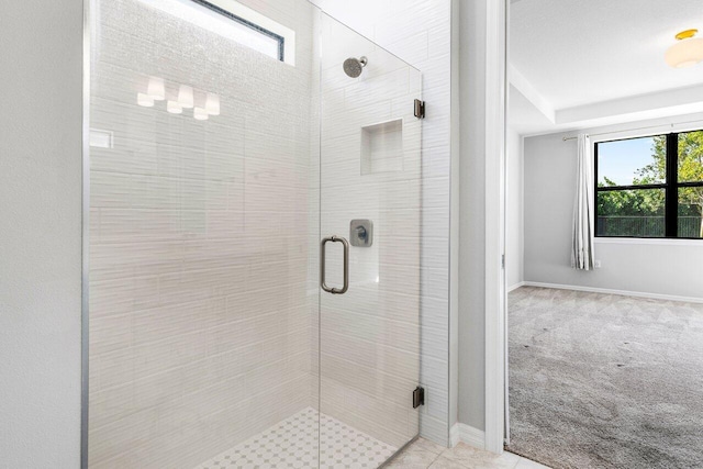 full bathroom with a shower stall and baseboards