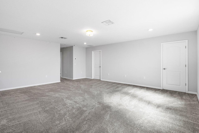 carpeted empty room with baseboards, visible vents, and recessed lighting