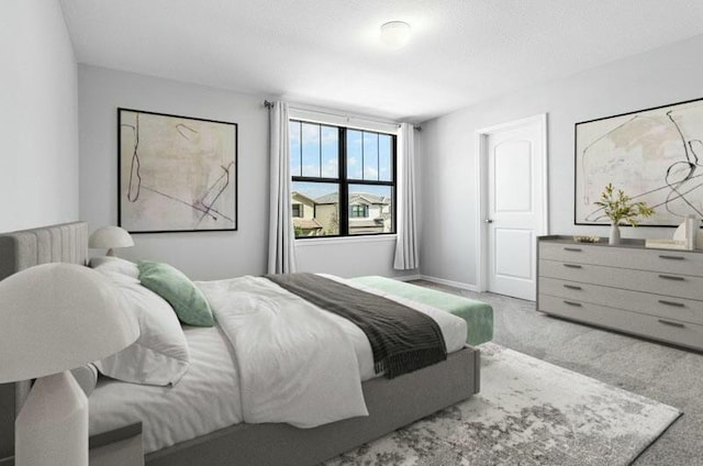 bedroom featuring light colored carpet and baseboards