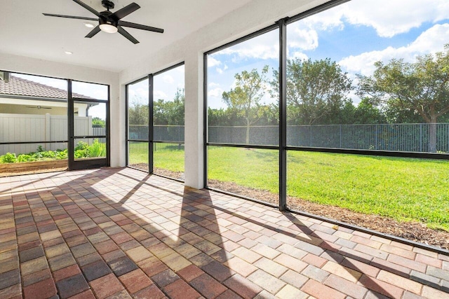 unfurnished sunroom featuring a ceiling fan