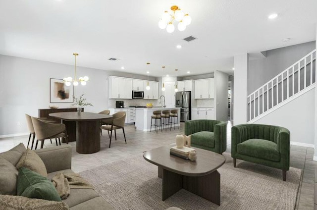 living area featuring a notable chandelier, recessed lighting, visible vents, stairway, and baseboards