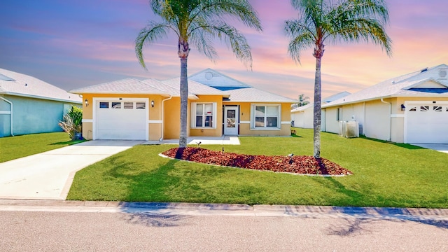 413 European Ln, Fort Pierce, FL 34982 - view of front of home featuring concrete driveway, a lawn, a garage, and stucco siding