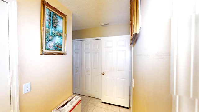 413 European Ln, Fort Pierce, FL 34982 - hallway featuring light tile patterned floors, visible vents, and a textured ceiling