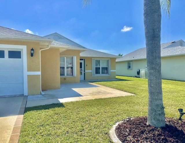 413 European Ln, Fort Pierce, FL 34982 - rear view of house with central air condition unit, roof with shingles, stucco siding, a lawn, and a patio