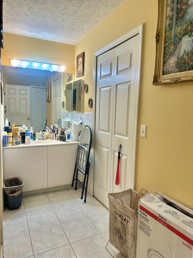 bathroom with vanity, a textured ceiling, and tile patterned floors