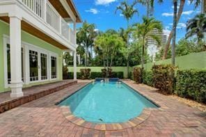 pool with french doors and a patio