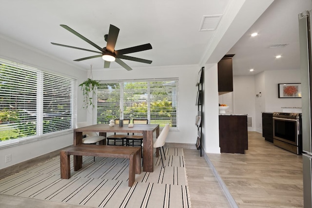 dining area with a wealth of natural light, ornamental molding, light wood-type flooring, and visible vents