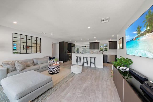 living area featuring recessed lighting, visible vents, and light wood-style floors