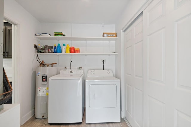 laundry room featuring laundry area, water heater, separate washer and dryer, and light wood finished floors