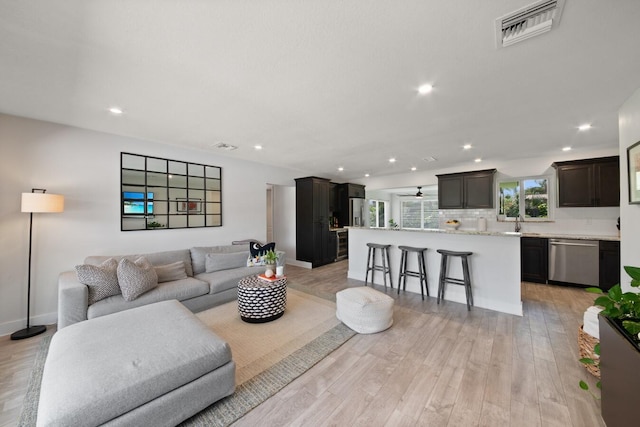 living room featuring recessed lighting, visible vents, light wood-style flooring, and baseboards