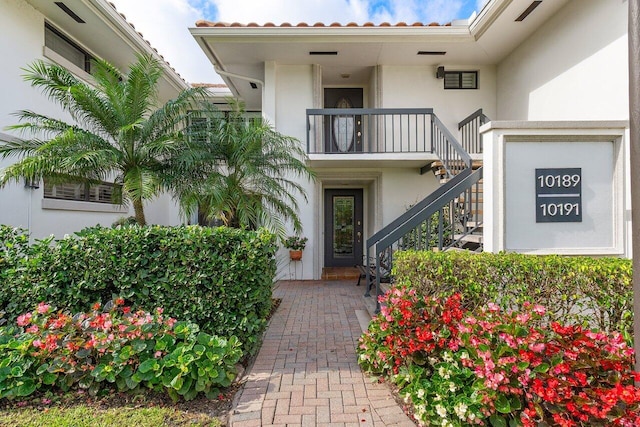 doorway to property with a tiled roof and stucco siding