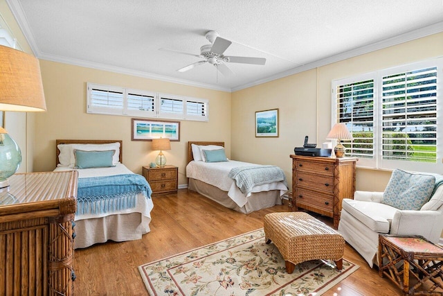 bedroom with ornamental molding, ceiling fan, a textured ceiling, and wood finished floors