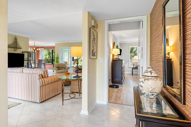 corridor with light tile patterned floors, a chandelier, a wealth of natural light, and crown molding