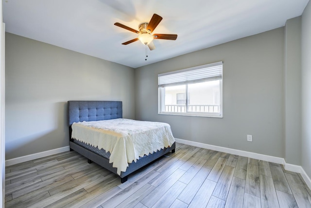 bedroom with ceiling fan, baseboards, and wood finished floors