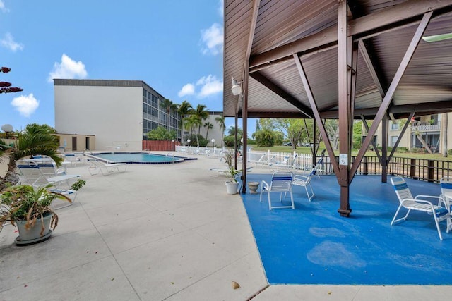 view of patio with fence and a community pool