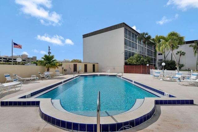 pool with a patio area and fence