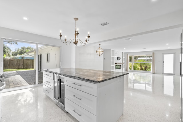 kitchen with light speckled floor, beverage cooler, open floor plan, and visible vents