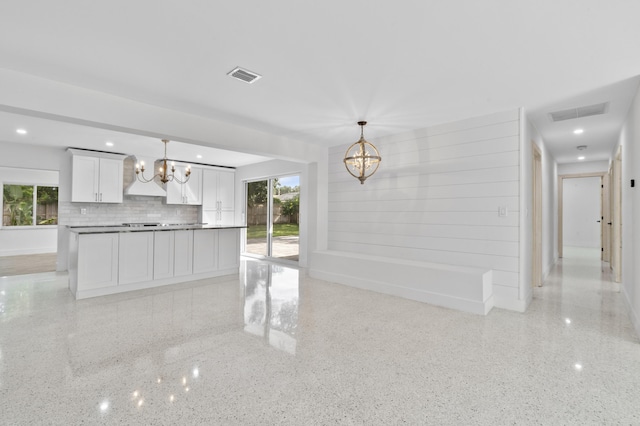 kitchen with light speckled floor, visible vents, plenty of natural light, and an inviting chandelier