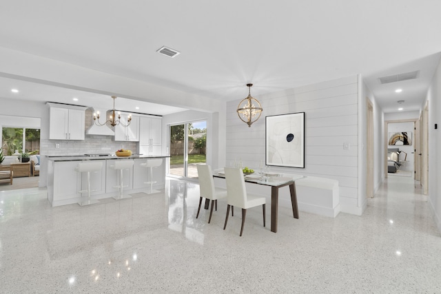 dining room featuring light speckled floor, visible vents, and an inviting chandelier