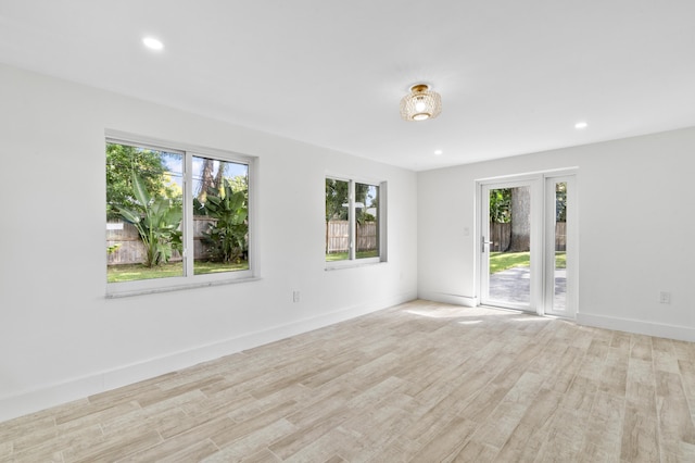 unfurnished room with baseboards, wood finished floors, and recessed lighting