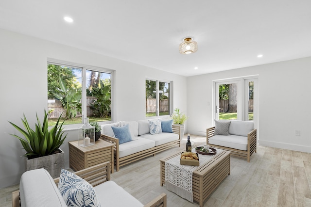 living room with light wood-style flooring, baseboards, and recessed lighting