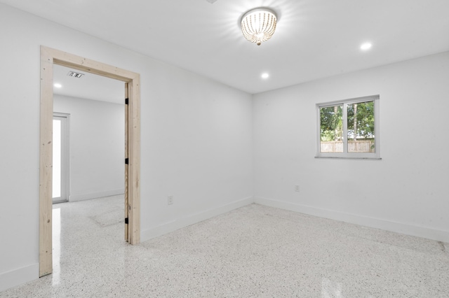 spare room with recessed lighting, visible vents, baseboards, and speckled floor