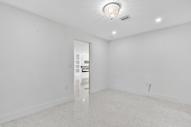 empty room with recessed lighting, visible vents, baseboards, and speckled floor