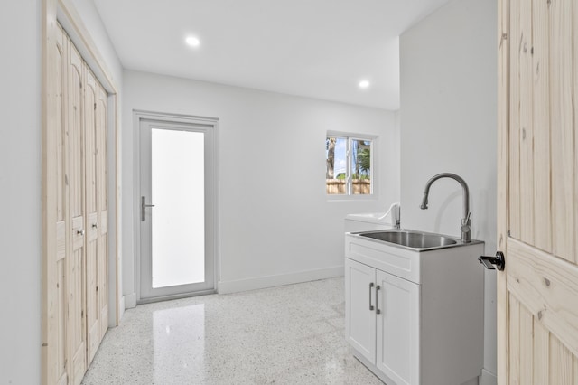 interior space with baseboards, a sink, and recessed lighting