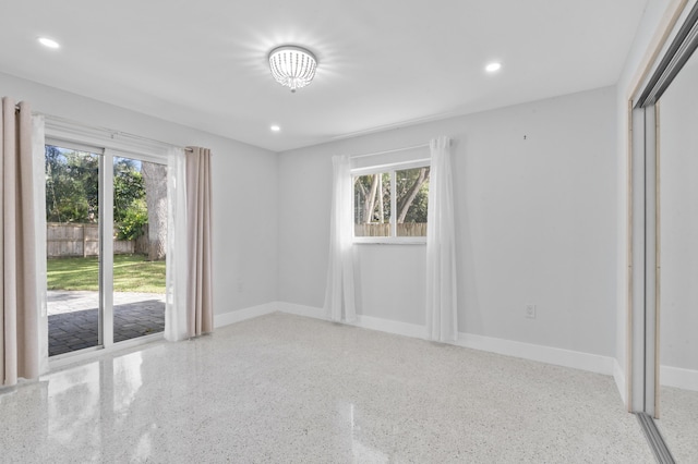 unfurnished room with recessed lighting, baseboards, and speckled floor