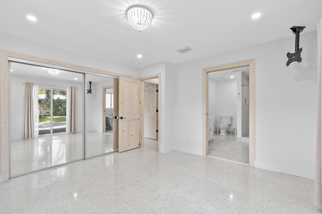 spare room featuring recessed lighting, visible vents, and speckled floor