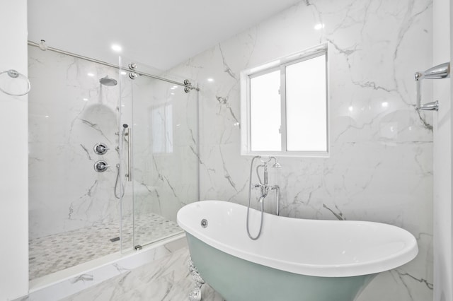 bathroom with marble finish floor, a marble finish shower, stone wall, and a freestanding bath