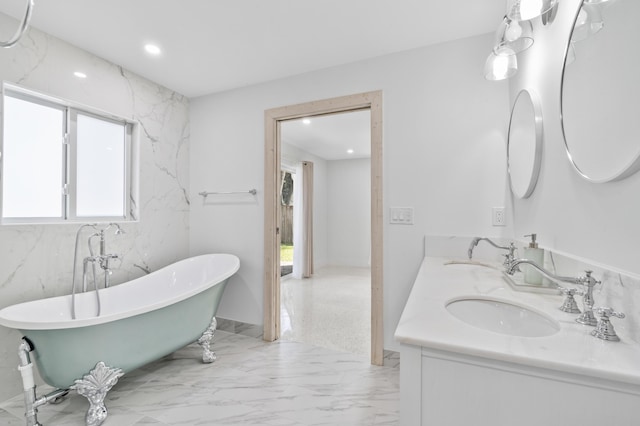 bathroom with a soaking tub, marble finish floor, a sink, and recessed lighting